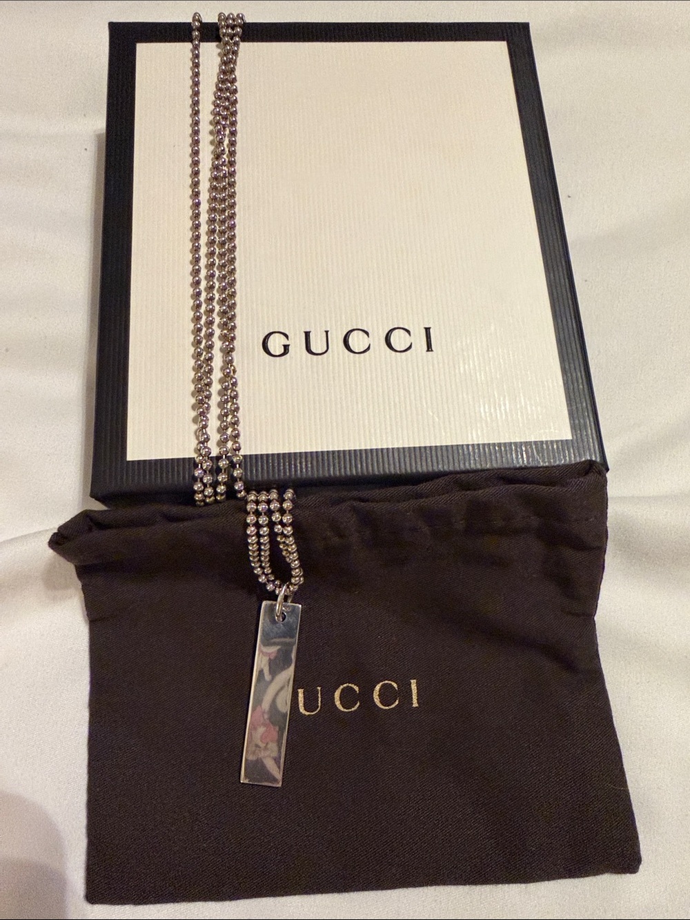 This Gucci sterling silver necklace w/ a rectangle pendant & double ball chain.
